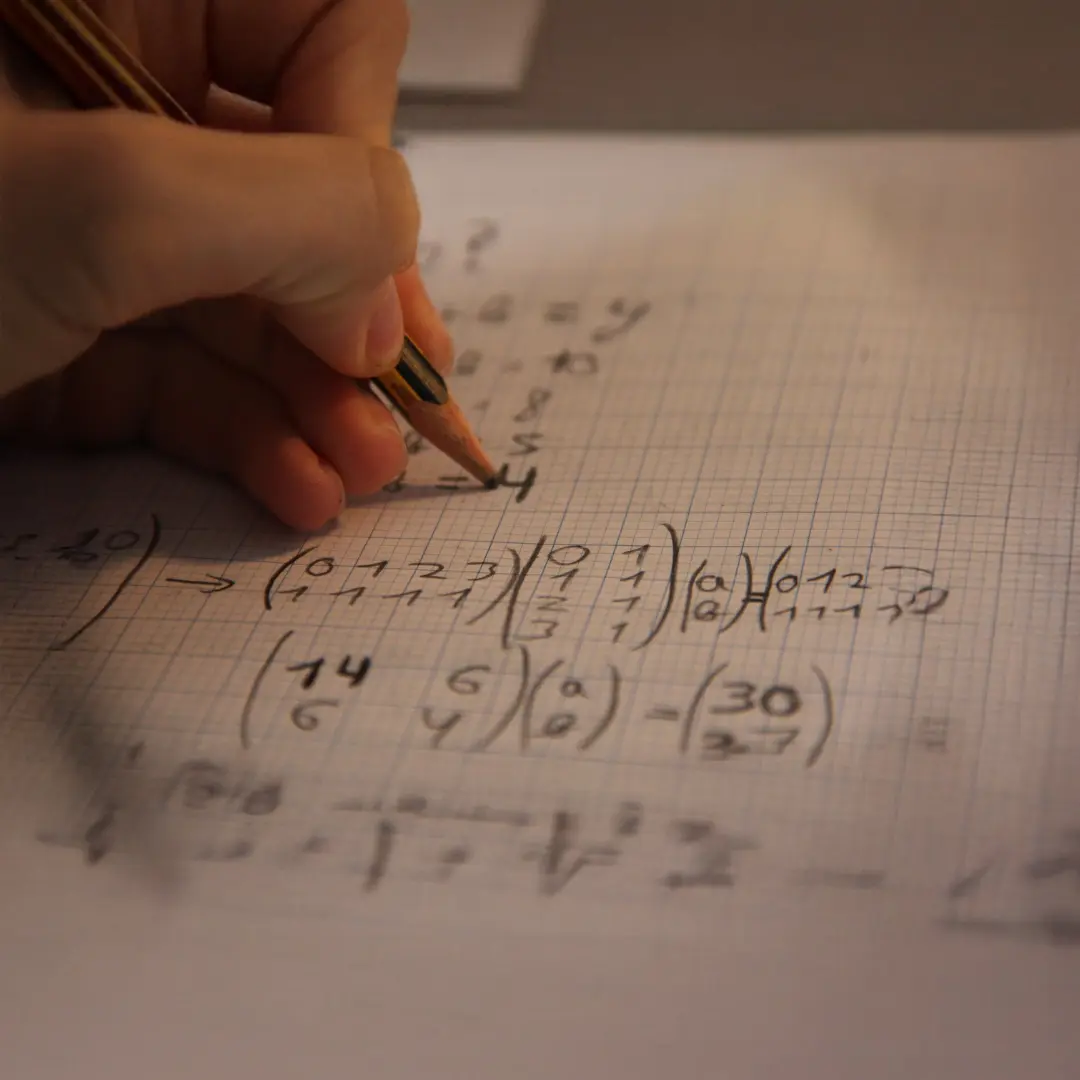 A student writing mathematical equations on graph paper, reflecting focus, curiosity, and the engaging problem-solving approach of our online math tuition platform.